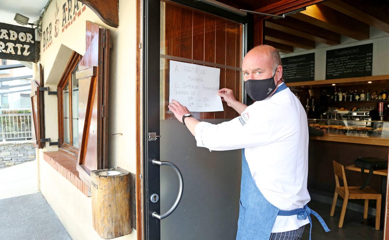 En el bar Aratz ayer colocaron un cartel en la puerta, informando del nuevo horario de atención en el interior desde hoy.