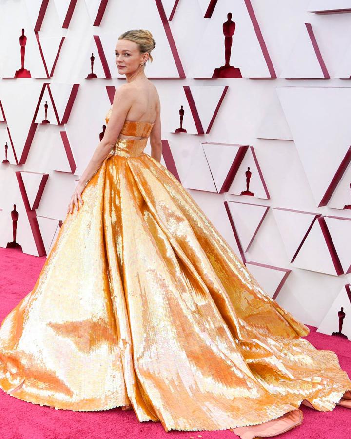 Este Valentino de la colección primavera-verano 2021 de Alta Costura, compuesto por una lentejuela XL dorada, ha sido otra de las joyas de la corona de la 'red carpet' y lo ha defendido Carey Mulligan. Con un escote palabra de honor, el 'cut out' por bandera y 'extra' de volumen en la falda con terminación en cola, no ha defraudado