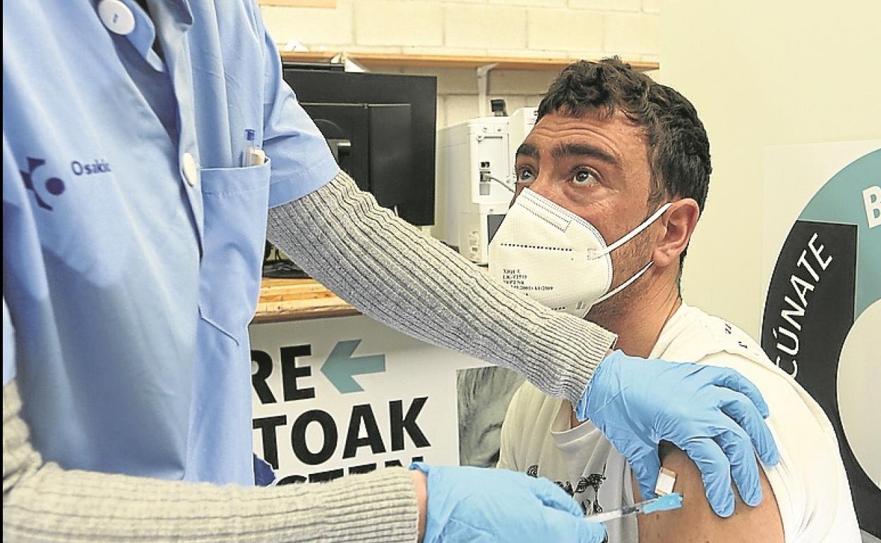 Un trabajador de servicios esenciales recibe la vacuna en el recinto de Illunbe.