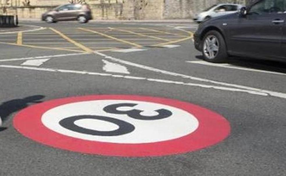 Un operario coloca una señal con la nueva limitación de 30 kilómetros hora. 