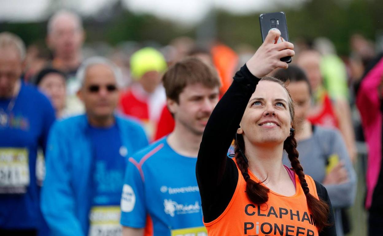 Una joven hace un selfie en una carrera deportiva en Londres, que ha servido de ensayo para competiciones ya sin mascarilla. 