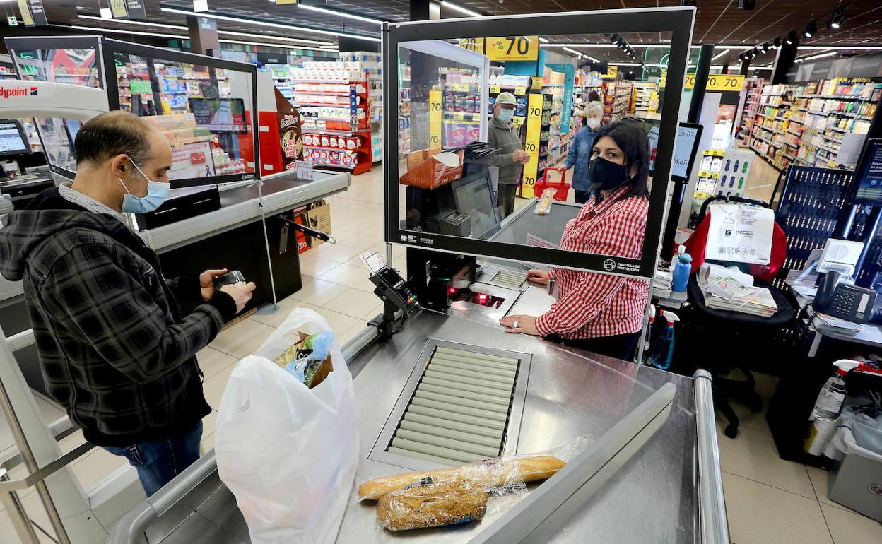 Un cliente paga por su compra en un supermercado de Eroski en San Sebastián. 