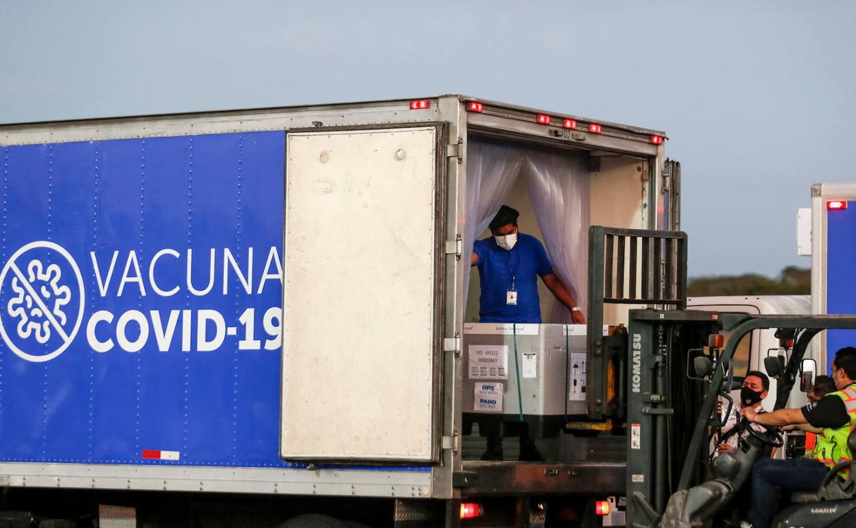 Operarios recogen cajas con diferentes paquetes de viales de AstraZeneca.