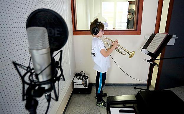 Un joven alumno graba con su trompeta en uno de los estudios de la Escuela.