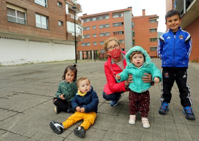 Imagen secundaria 1 - Iban y Maite, con sus hijos Sua y Ekaitz, en el parque Alfaro del barrio de Etxeberrieta, en Andoain. Tere, con sus cuatro nietos. «Un barrio sin niños es triste», dice. Oihana y su hija Lorea, de cinco años, ante uno de los nuevos edificios del barrio. 