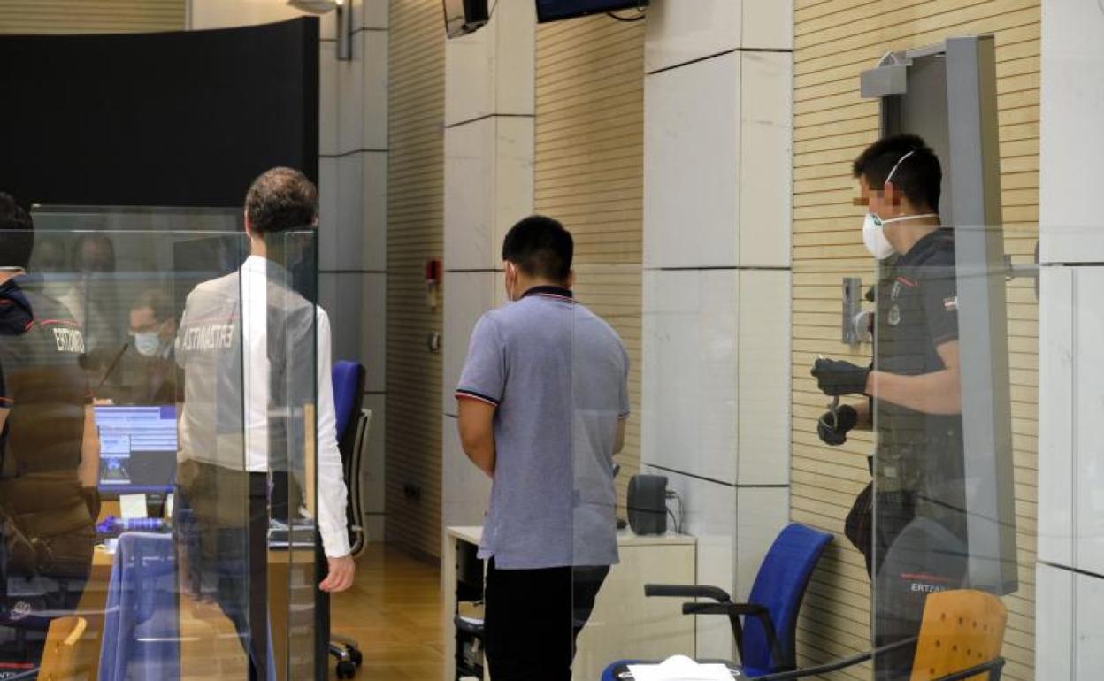 El acusado entra en la sala de vistas custodiado por la Ertzaintza. 