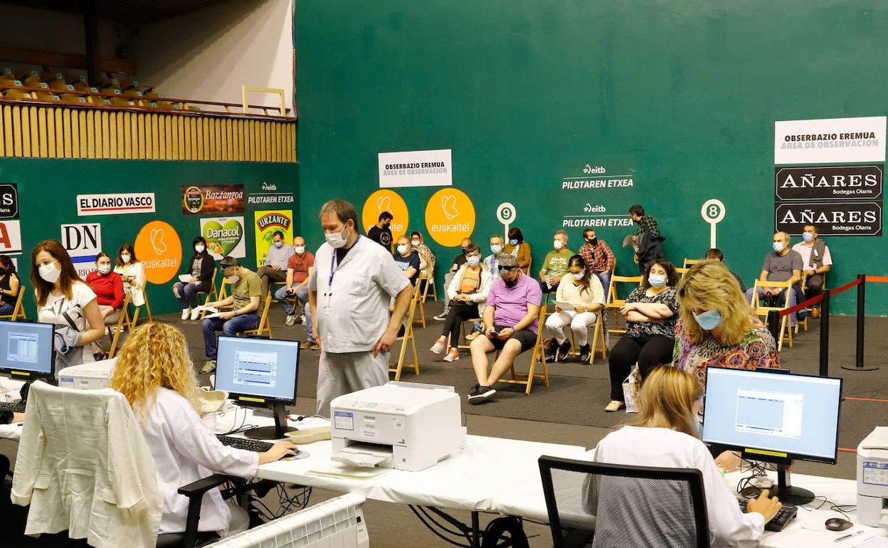 Varias personas asisten a su cita para vacunarse en el frontón Astelena de Eibar.