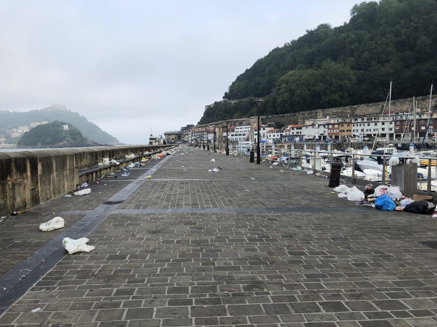 El puerto donostiarra ha amanecido cubierto de restos de plásticos y cristales después de una noche de botellón