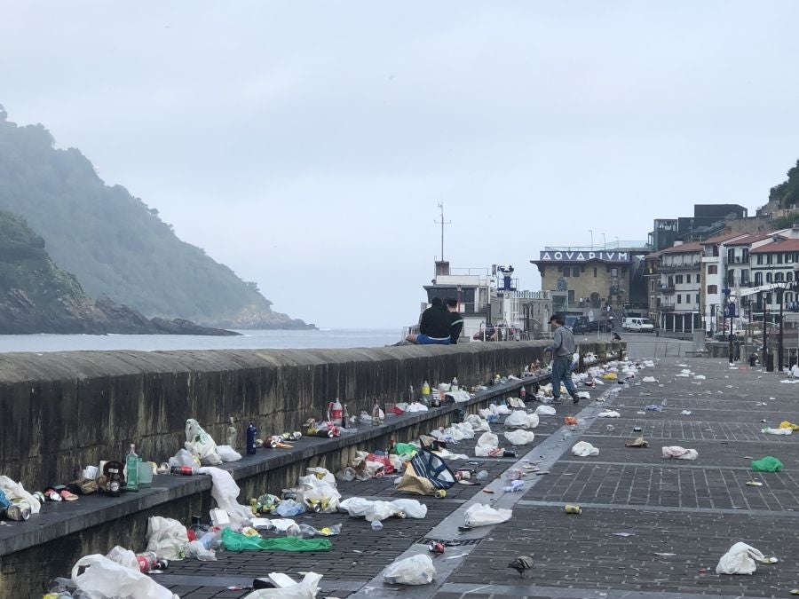 El puerto donostiarra ha amanecido cubierto de restos de plásticos y cristales después de una noche de botellón