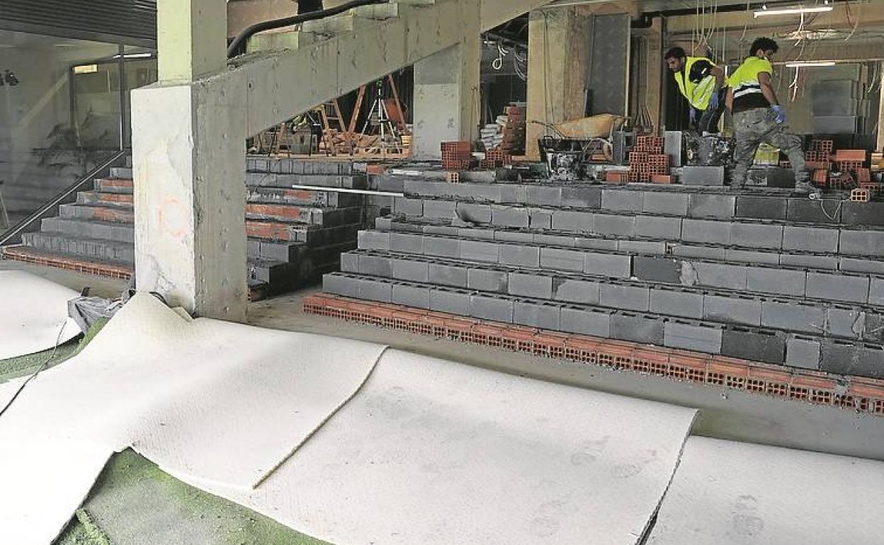 Operarios realizan trabajos de remodelación de la zona de acceso a vestuarios en Anoeta. 