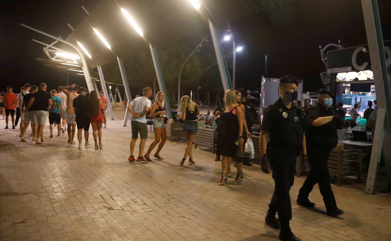 Dos policías patrullan una zona de copas en Mallorca frecuentada por jóvenes turistas. 