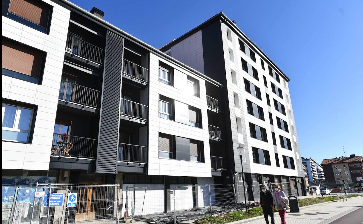 Un pareja pasea por delante de una vivienda en reformas del barrio donostiarra de Txomin. 