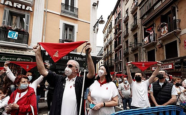 Ciudadanos vestidos de blanco y rojo en la en la plaza Consistorial a las 12 del mediodía, momento en que se habría lanzado el chupinazo anunciador de las fiestas.