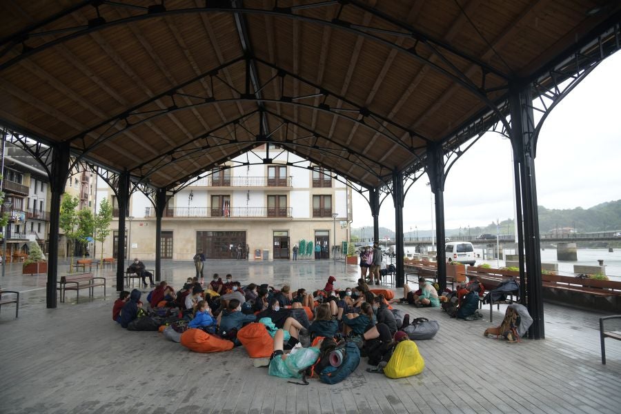 Los peregrinos descansan en una plaza de Orio. Gracias a esta infraestructura han podido recargar fuerzas y sin mojarse.