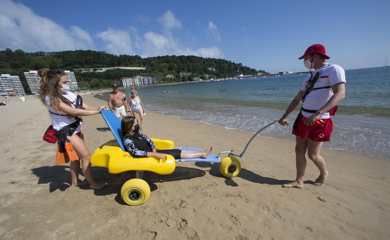 Los socorristas arrastran la silla hasta la orilla. 