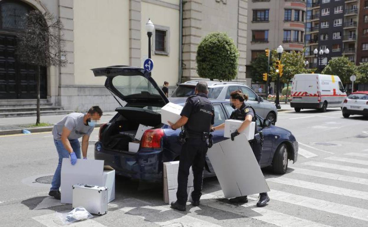 Agentes de la Policái Científica introducen en una coche cajas con presunto material probatorio del delito sexual cometido.
