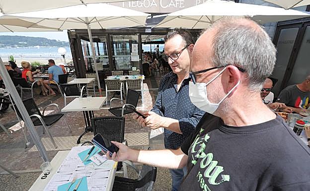 Sin problemas. El donostiarra Jordi Ferrer muestra el pasaporte Covid en el Café Hegoa de Hendaia.
