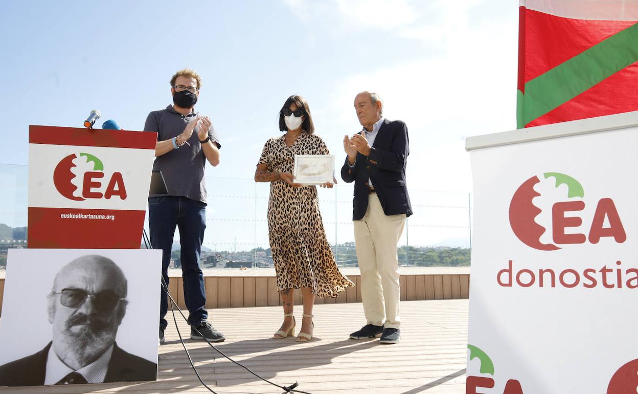 El coordinador de EA en Donostia, Javier Estébanez y el exlehendakari, Carlos Garaikoetxea, hacen entrega de un cuadro conmemorativo a la nieta de Joseba Elósegui, Amaia Rascón