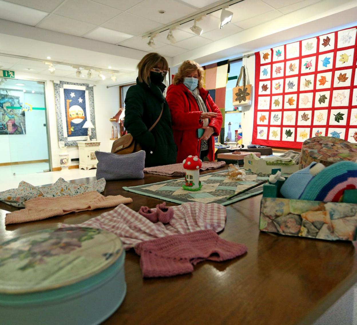 Dos mujeres visitan la exposición de Gaxuxa. 