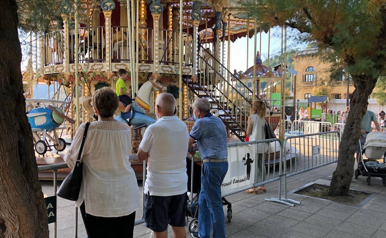 Abuelos observando a sus nietos en el tiovivo de Alderdi Eder 