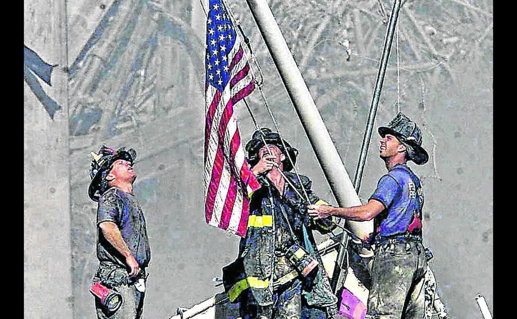 Tres bomberos de Brooklyn izan una bandera norteamericana en el WTC el 11 de septiembre de 2001.