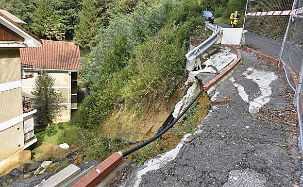 Imagen principal - Estado de la calzada que sostiene la ladera y detalle del material caído desde la ladera. El impacto de la roca dejó a la vista el forjado de la fachada. 