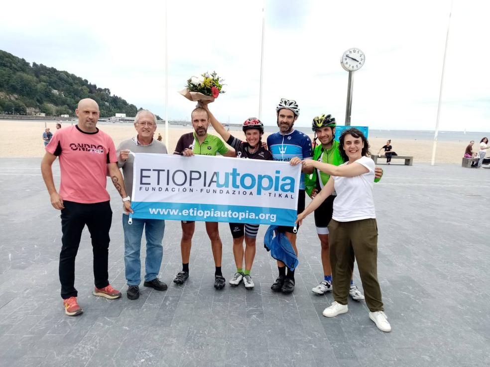 Miembros de la Fundación Etiopía Utopía entregan un ramo de flores a los ciclistas al llegar a Hondarribia. 