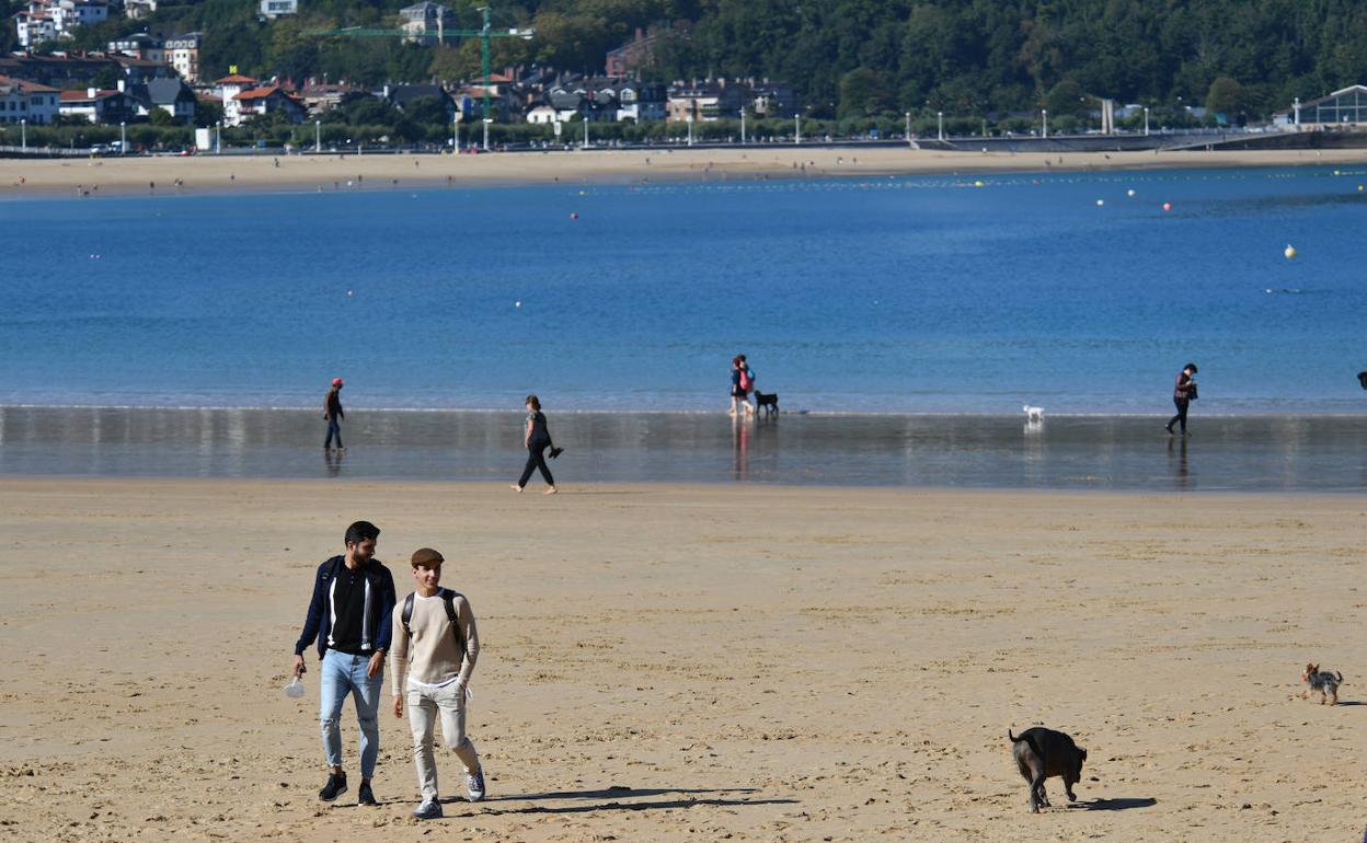 Varias personas pasean por la playa de La Concha este jueves. 