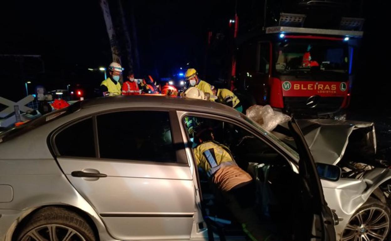 Bomberos rescatan a uno de los heridos del interior del coche accidentado esta mañana en Lezo. 