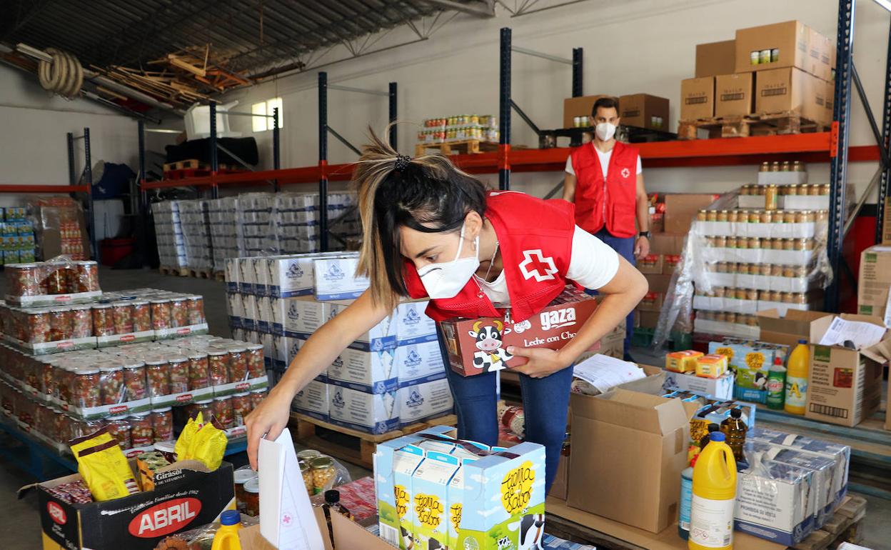Dos voluntarios de Cruz Roja organizan el almacén de alimentos.