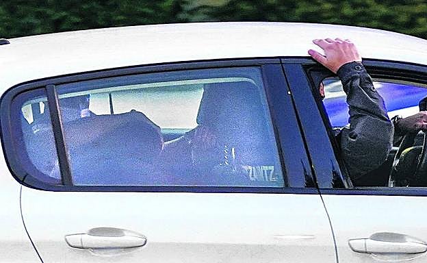 Los agentes trasladanen el asiento trasero de un coche al alumno detenido como presunto autor de los disparos. 