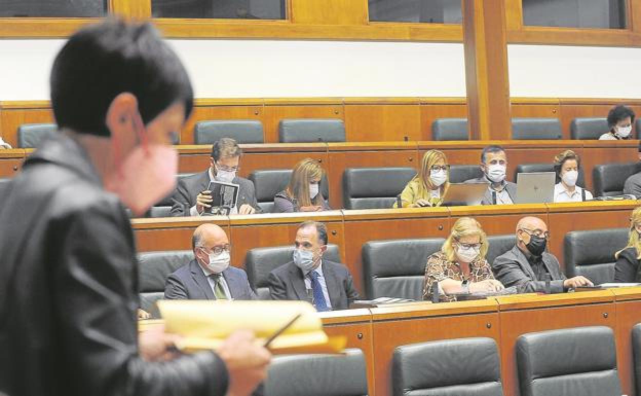 La portavoz de EH Bildu, Maddalen Iriarte, sigue el pleno de ayer en el Parlamento Vasco con representantes de PP y PSE al fondo. 