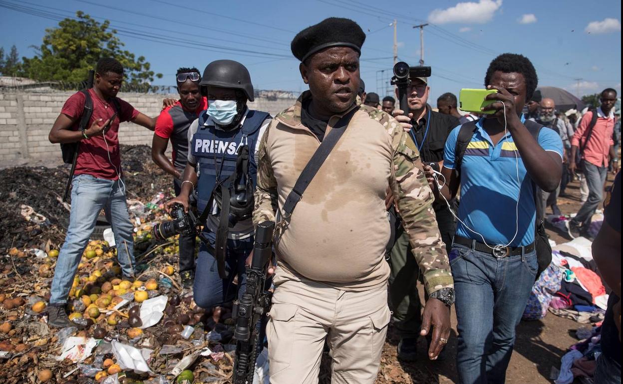 El líder de la principal banda armada de Haití, Jimmy Cherizier, alias 'Barbecue', vestido de militar y armado, camina por una calle de Puerto Príncipe.