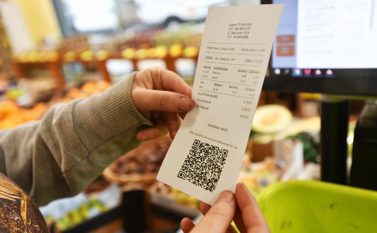 Una comerciante revisa una factura emitida ya con TicketBai. Los clientes pueden comprobar la transacción mediante el código QR. 