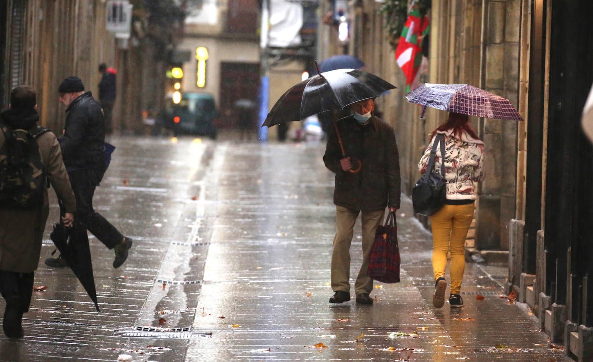 Varias personas hacen recados por la Parte Vieja de San Sebastián.