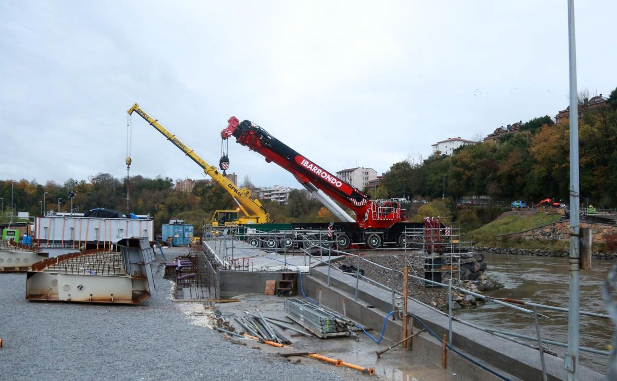 La grúa roja de gran tonelaje que moverá las piezas que componen la estructura del puente de Astiñene se instala desde ayer sobre una península de tierra en la orilla de Loiola. 