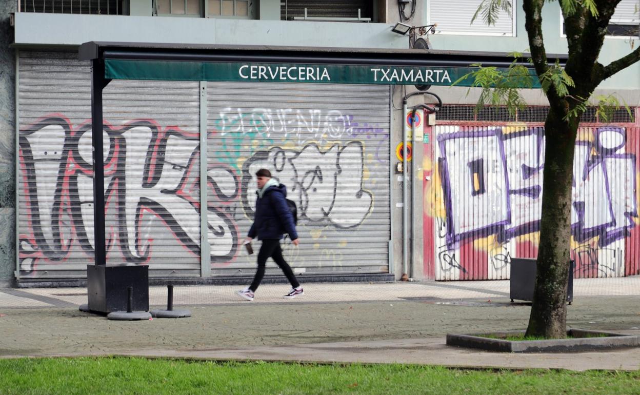 Grafitis en una persiana y en la puerta de un garaje de la plaza de las Ferrerías, en el barrio de Amara. 