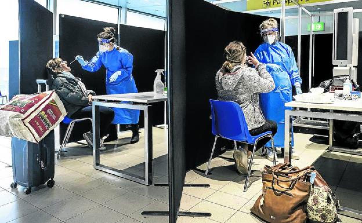 Sanitarios realizan un test PCR a viajeros llegados desde Sudáfrica a Holanda. 