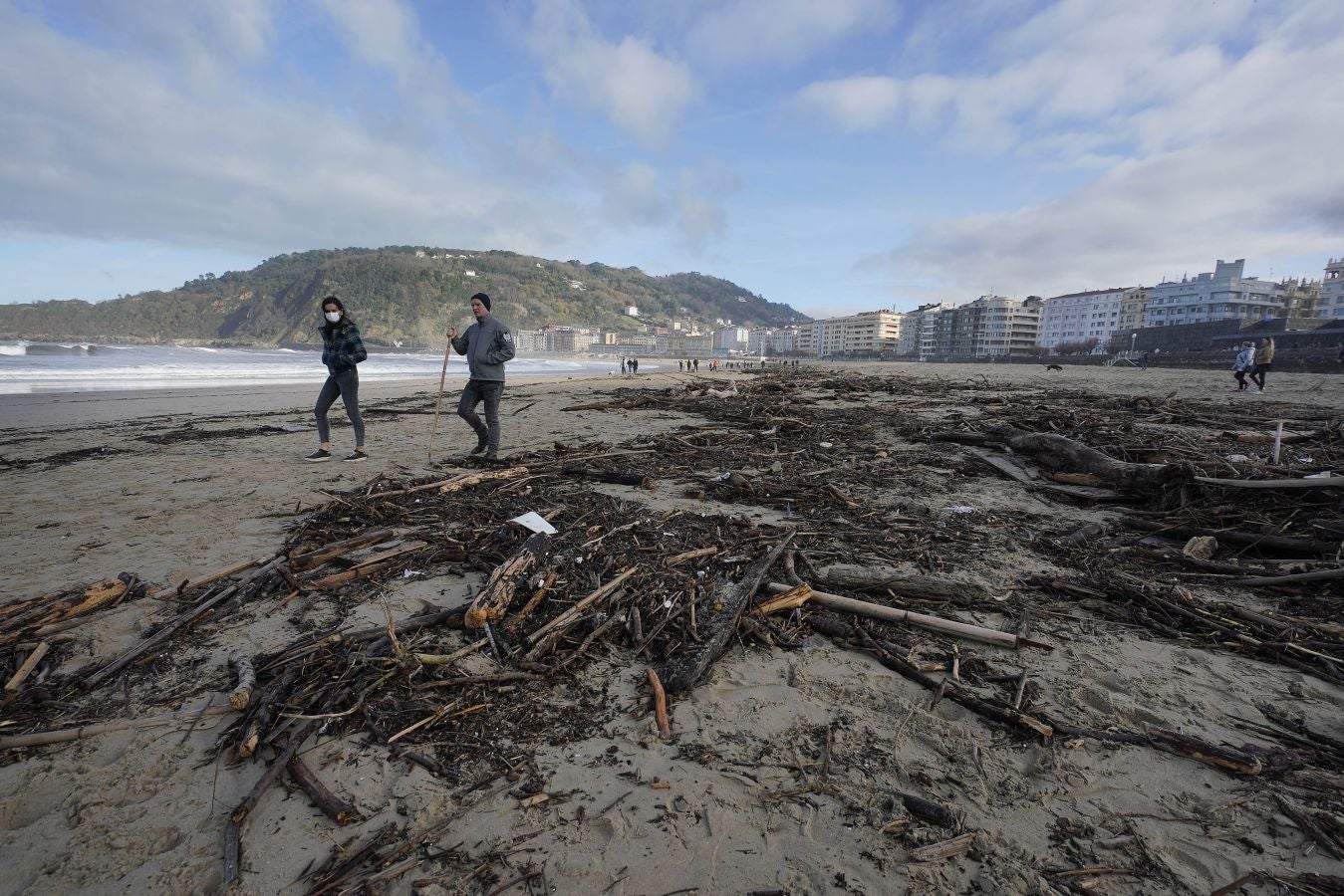 El arenal de la Zurriola se ha cubierto de troncos tras el paso de la borrasca 'Barra'.