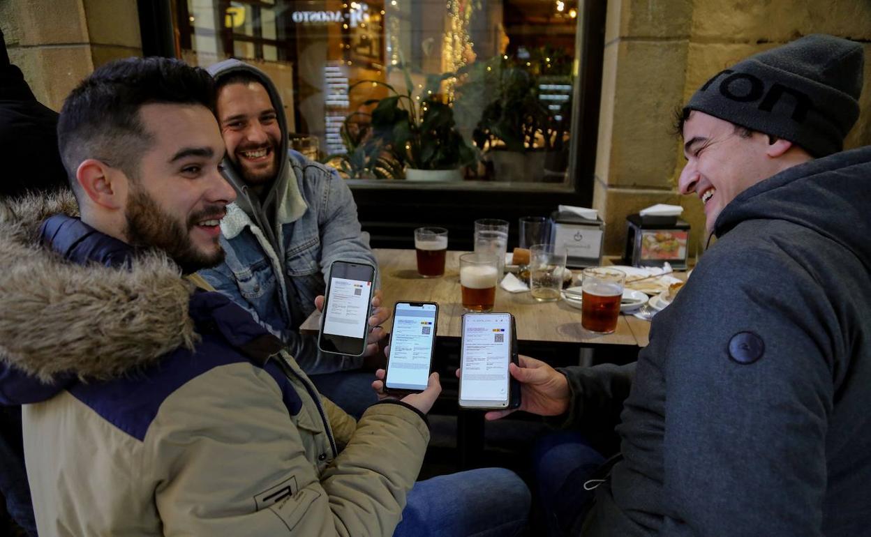 Clientes de un bar de San Sebastián muestran el pasaporte Covid.
