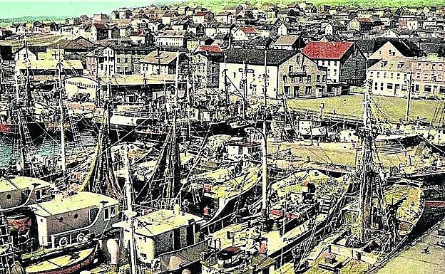 Imagen principal - Bacaladeros de Pasaia refugiados en Saint Pierre ante la amenaza de un ciclón en 1959, Juan Mari Benito Izaguirre y su libro.