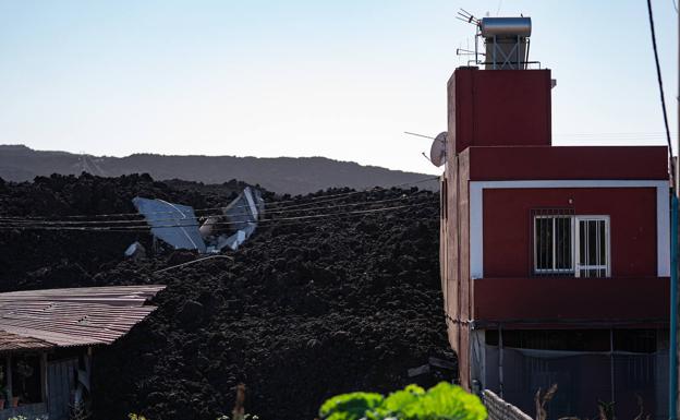 Casas medio atrapadas por la lava del volcán de La Palma..