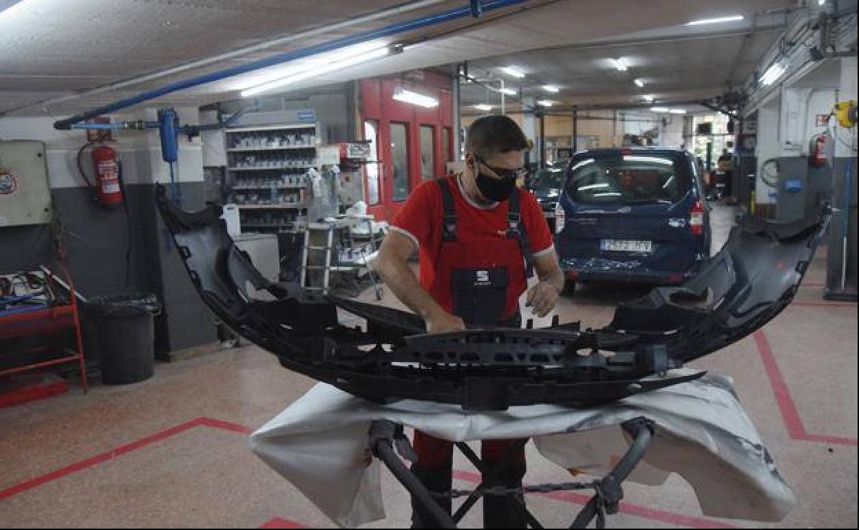 Un empleado trabaja en un taller de coches. 