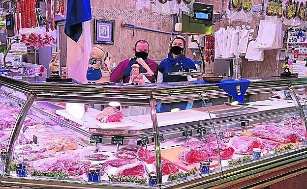 Miguel y Ramoni, de la carnicería Miguel Urrestarazu de La Bretxa, con espíritu positivo y con colores blanquiazules. 