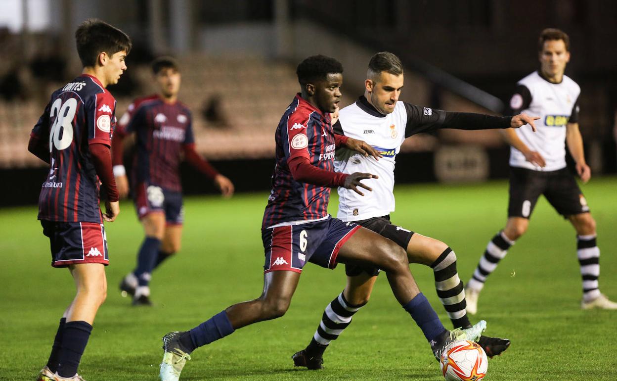 Alain Oyarzun disputa un balón con un jugador del Extremadura.