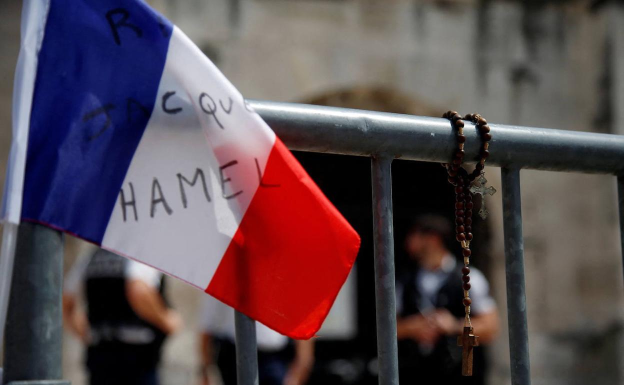 La bandera francesa rinde homenaje al sacerdote católico Jacques Hamel en la entrada de la iglesia de Saint-Etienne-du-Rouvray. 