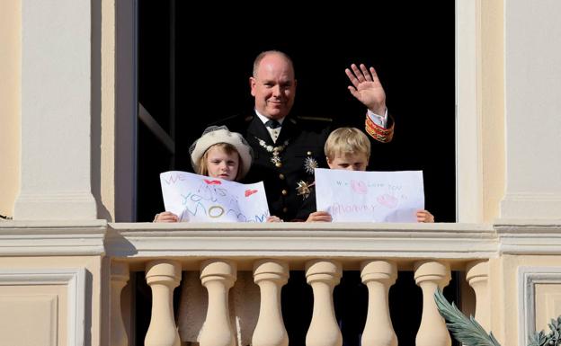 Jacques y Gabriella, con su padre Alberto, en el día Nacional de Mónaco con carteles en los que se podía leer «te echamos de menos, mami» y «te queremos».