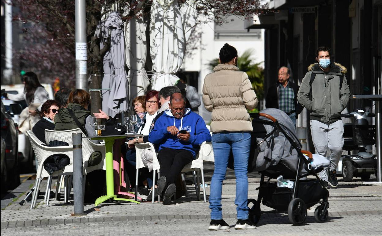 Gente en una terraza durante un día de sol. 
