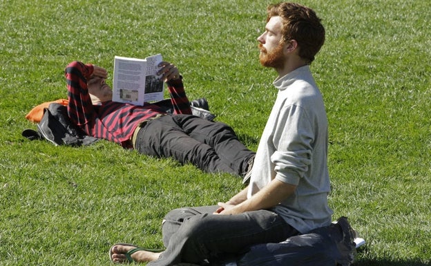 Un joven medita en un parque de California. 