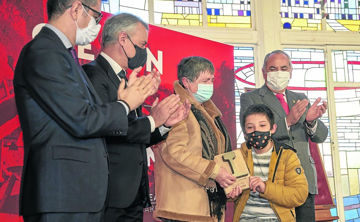 Félix Bolaños, Iñigo Urkullu e Iñaki Arriola, en el homenaje, junto a familiares de un víctima de trabajos forzados. 